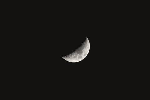 Luna en cuarto menguante sobre fondo negro