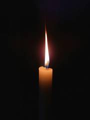 Llama de una vela encendida en la oscuridad