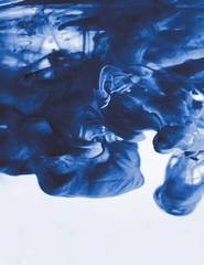 Nube de tinta azul que se despliega sobre fondo blanco