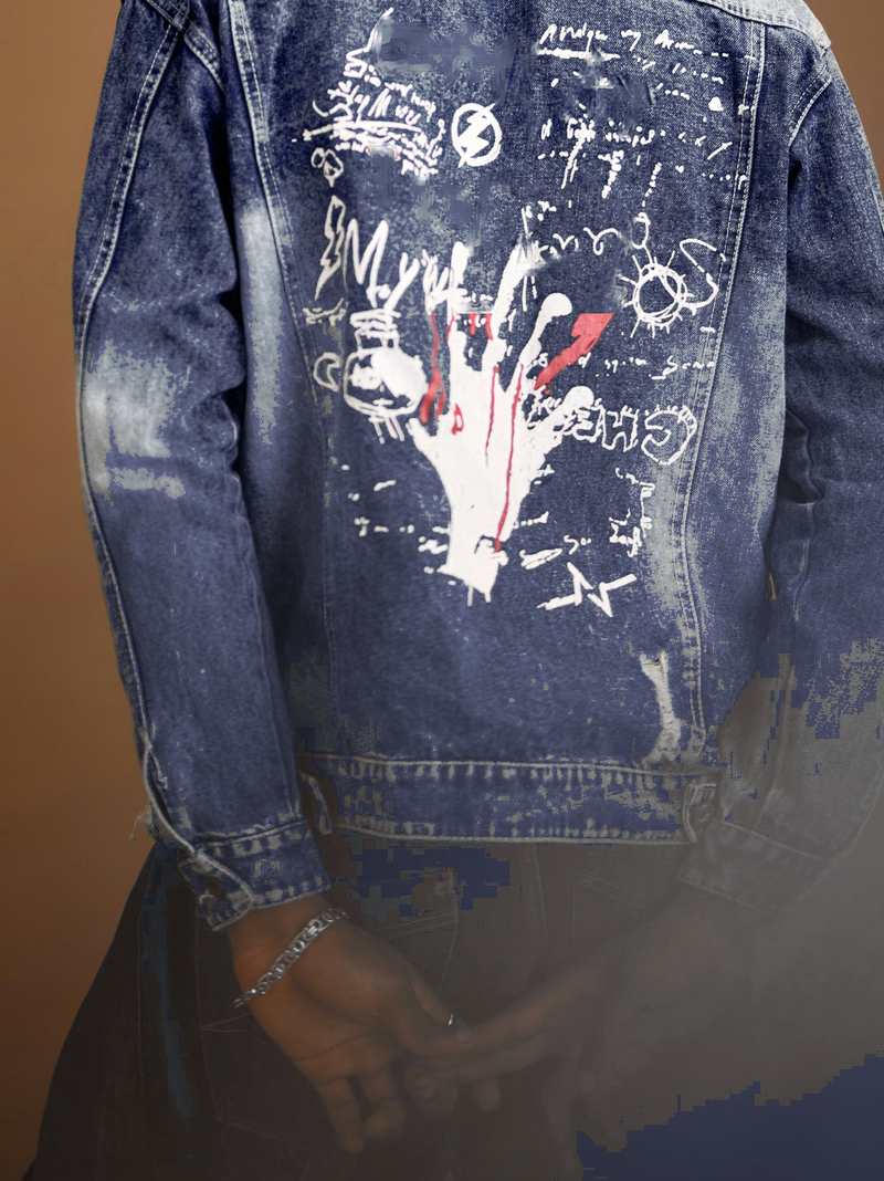 Persona de espaldas con una chaqueta de mezclilla pintada a mano, ante un fondo café
