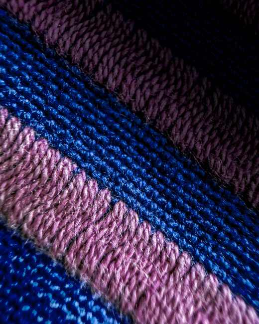 Primer plano de un tejido de punto con franjas azules y rosadas