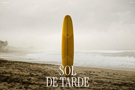 Fotografía de una tabla de surf en una playa al atardecer