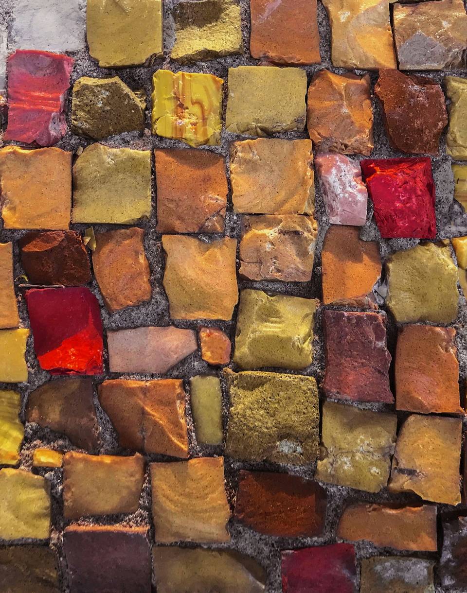 Mosaico de piedras pequeñas en ocres, naranjas y rojos