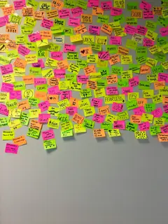 Notas adhesivas rosadas y amarillas sobre una pared