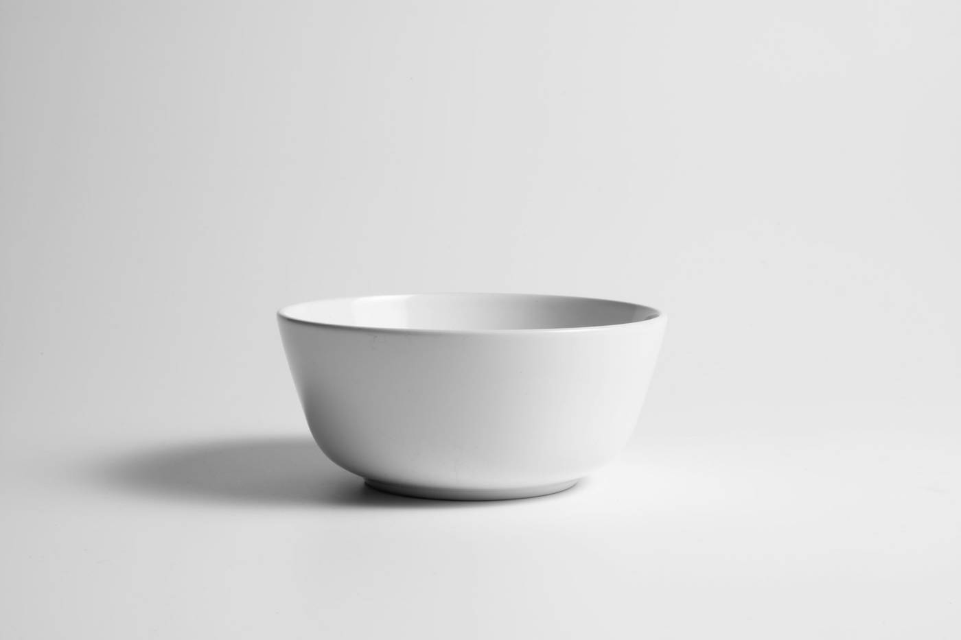 Cuenco blanco de cerámica sobre un fondo gris claro