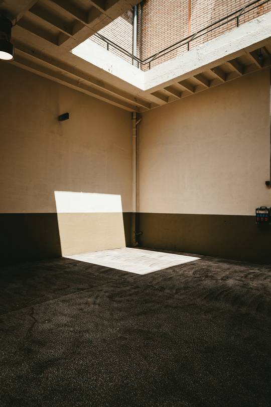 Sala amplia de paredes claras con un rayo de sol sobre el piso