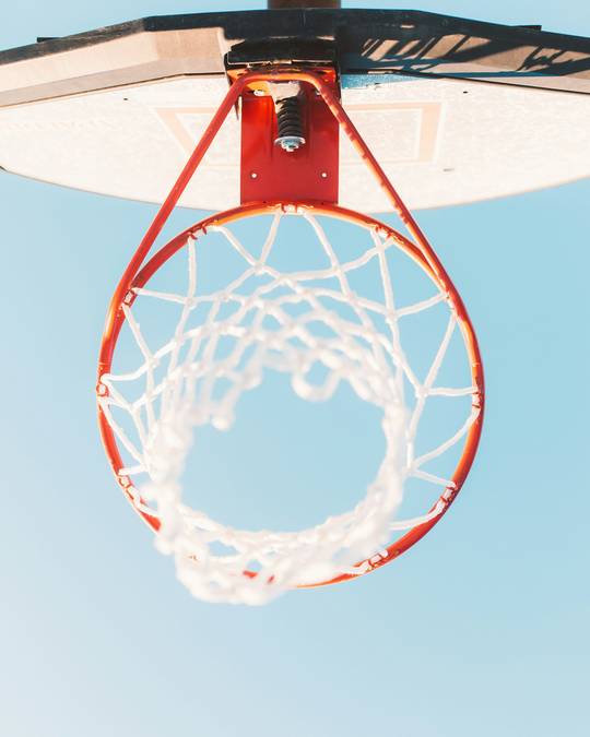 Aro de básquetbol visto desde abajo contra un cielo claro