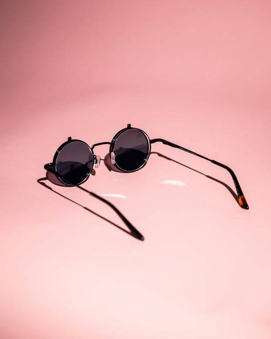 Gafas de sol redondas sobre un fondo rosa