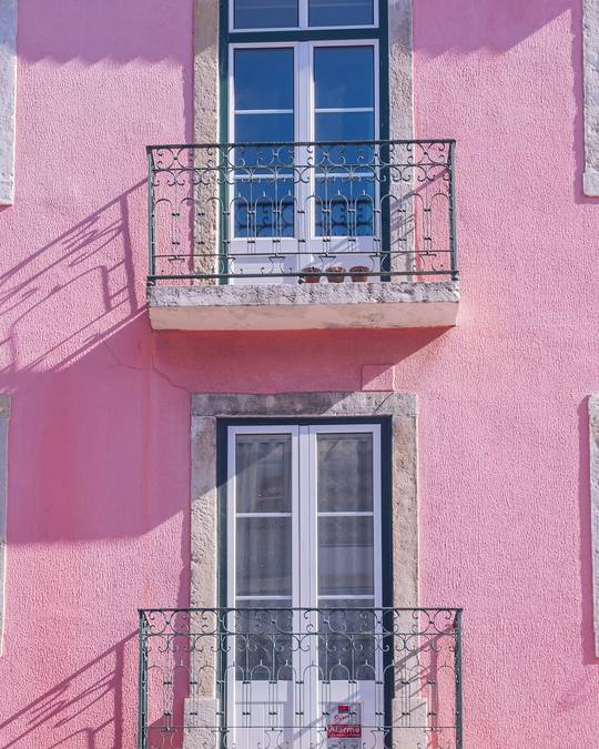 Fachada rosada con dos balcones