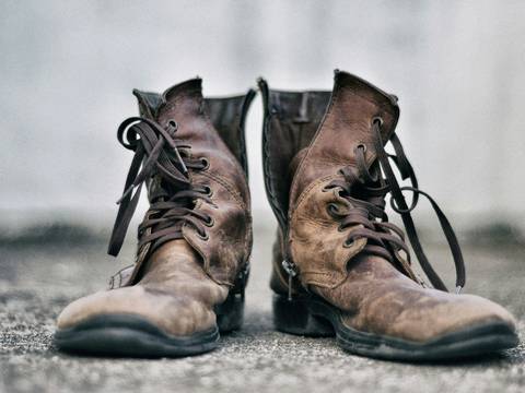 Botas de cuero gastadas sobre la grava