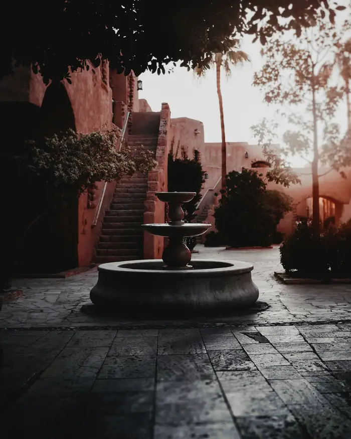 Fuente en un patio de terracota al atardecer