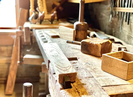 Banco de madera gastado, con un mazo y una caja de madera sobre la mesa