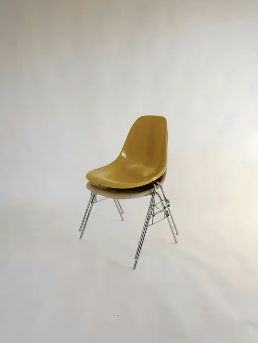Silla de concha color mostaza sobre un fondo blanco