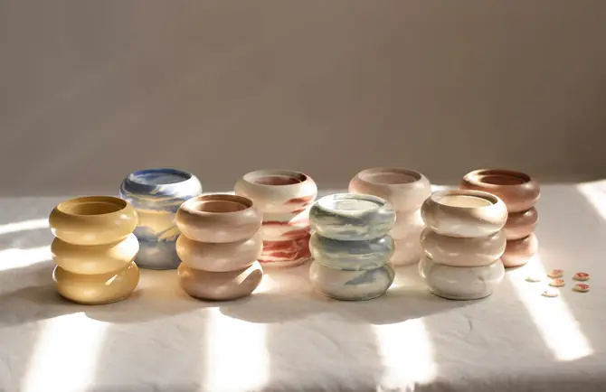 Jarros de cerámica en colores pastel bajo rayos de luz