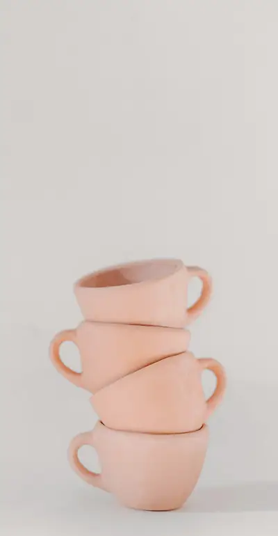 Tazas rosadas apiladas sobre un fondo claro