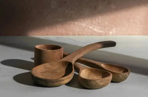 Cucharones y cuencos de madera sobre una mesa clara