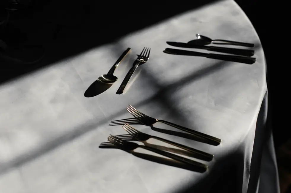 Cubiertos sobre un mantel con sombras largas