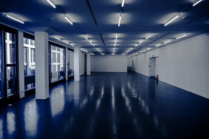 Sala vacía de piso azul brillante con luces en el techo