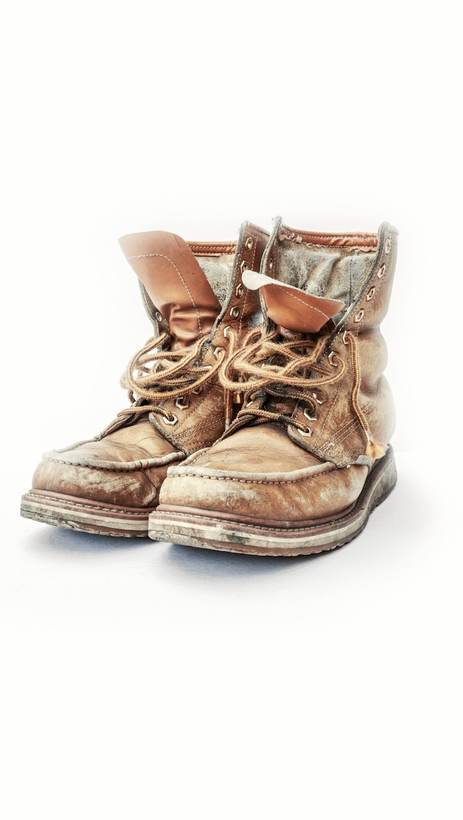 Par de botas de trabajo desgastadas sobre fondo blanco