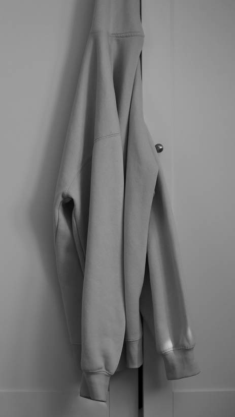 Sudadera gris colgada de una puerta, en blanco y negro