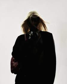 Figura de espaldas con chaqueta negra y el pelo al viento