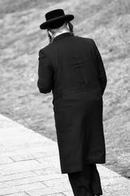 Figura de espaldas con sombrero y abrigo largo, en blanco y negro