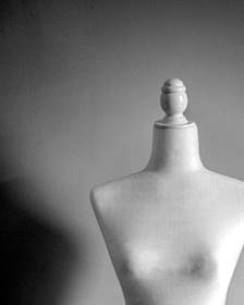 Maniquí de costura blanco sobre un fondo gris claro