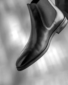 Botines de cuero marrón con elástico lateral, suspendidos en el aire