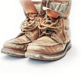 Par de botas de trabajo desgastadas sobre fondo blanco