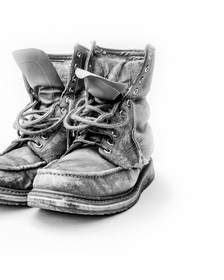 Par de botas de trabajo desgastadas sobre fondo blanco