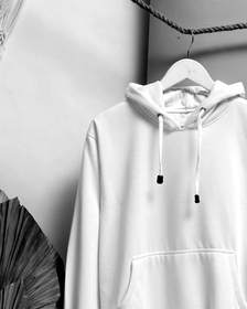 Sudadera blanca con capucha colgada de una cuerda