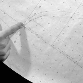 Manos sobre un patrón de papel, en blanco y negro