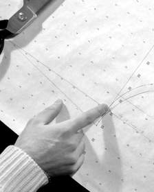 Manos sobre un patrón de papel, en blanco y negro