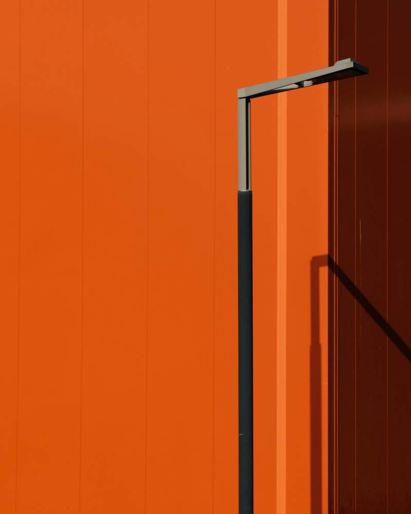 Muro naranja con un poste de luz
