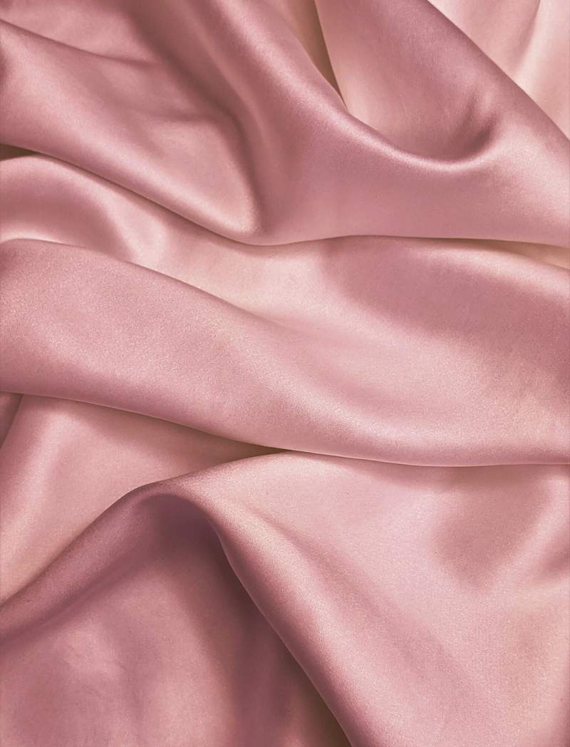 Tela de satén rosa con pliegues suaves