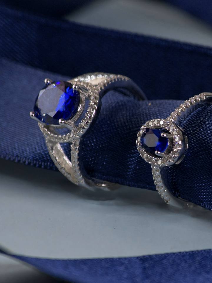 Dos anillos de zafiro sobre una cinta azul noche.