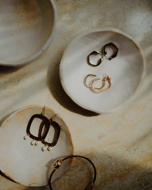 Aros de aro fino sobre platos de cerámica clara.