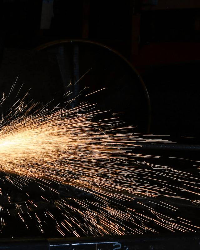 Chispas saliendo de un corte de metal en un taller oscuro