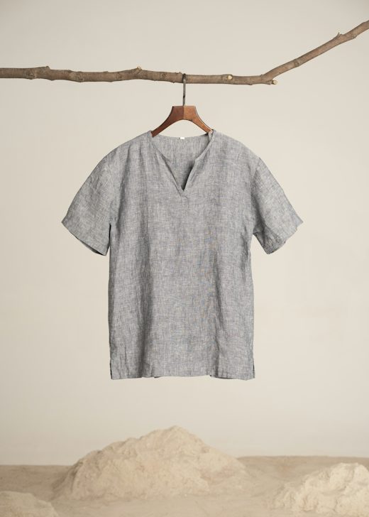 Camisa gris jaspeada con cuello en V colgada de una rama