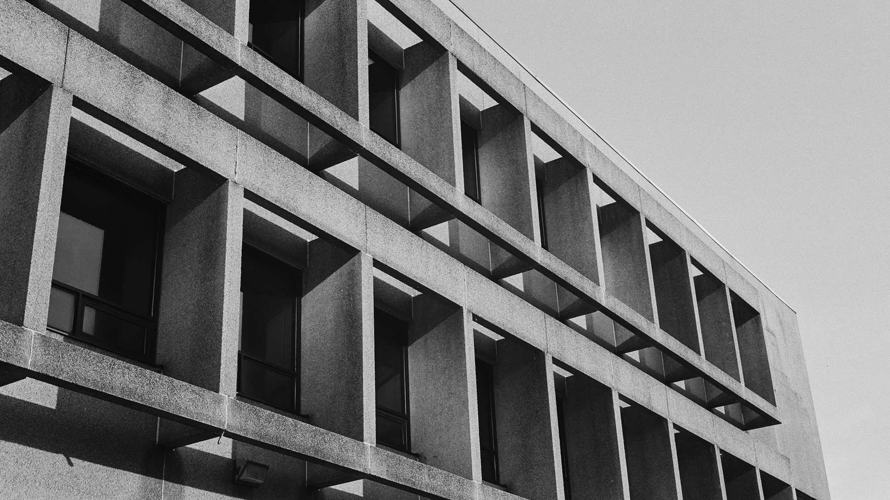 Edificio de hormigón con ventanas profundas, visto desde abajo
