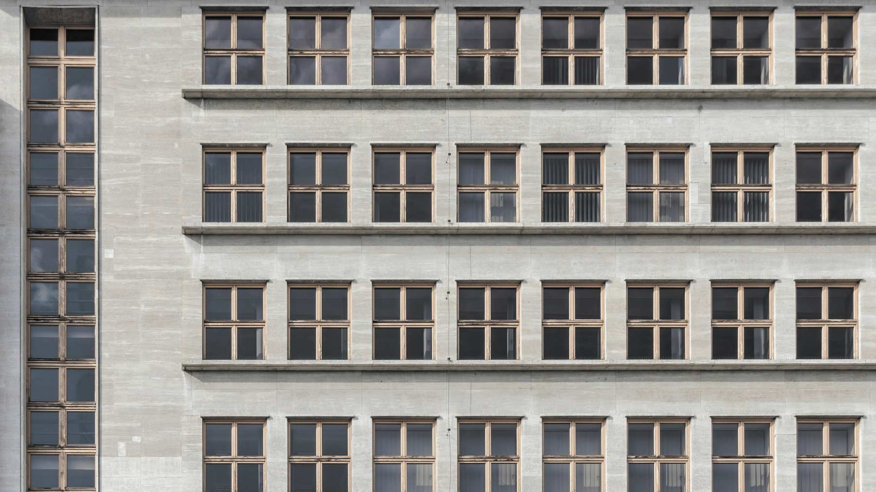 Fachada gris con una trama regular de ventanas