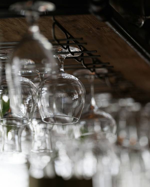 Copas colgadas boca abajo sobre una barra, desenfocadas