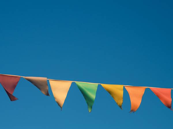 Banderines triangulares de colores contra un cielo azul