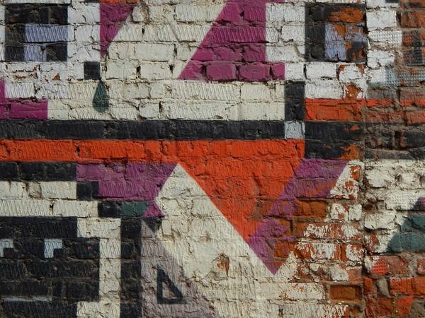 Muro de ladrillo pintado con un motivo geométrico de pixeles
