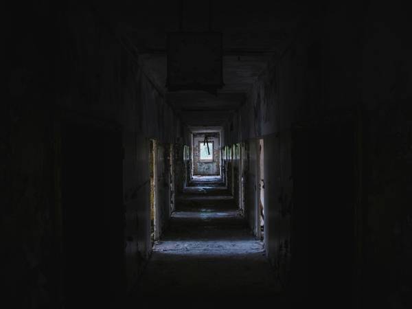 Pasillo oscuro de un edificio abandonado que se pierde en la lejanía