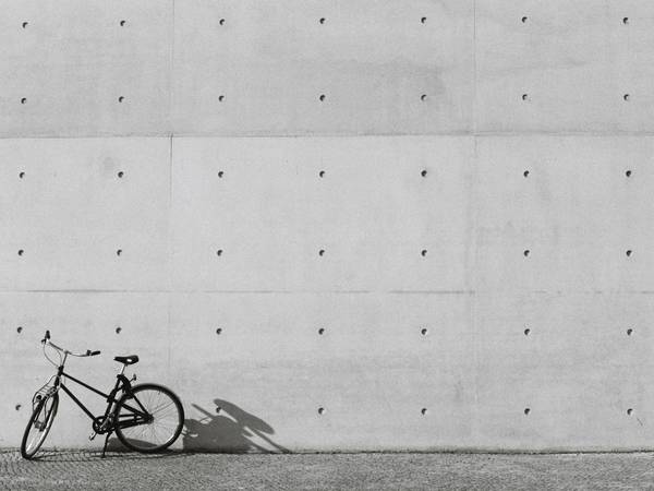 Bicicleta apoyada en un muro de hormigón con perforaciones