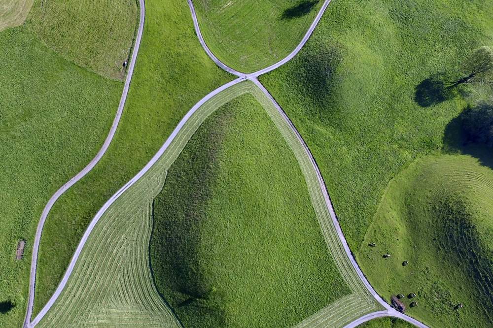 Vista aérea de lomas de hierba atravesadas por caminos que dibujan anillos