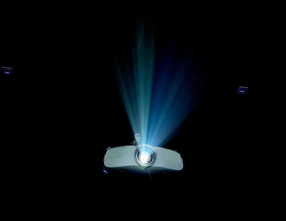 Haz de luz azul saliendo de un proyector en una sala a oscuras