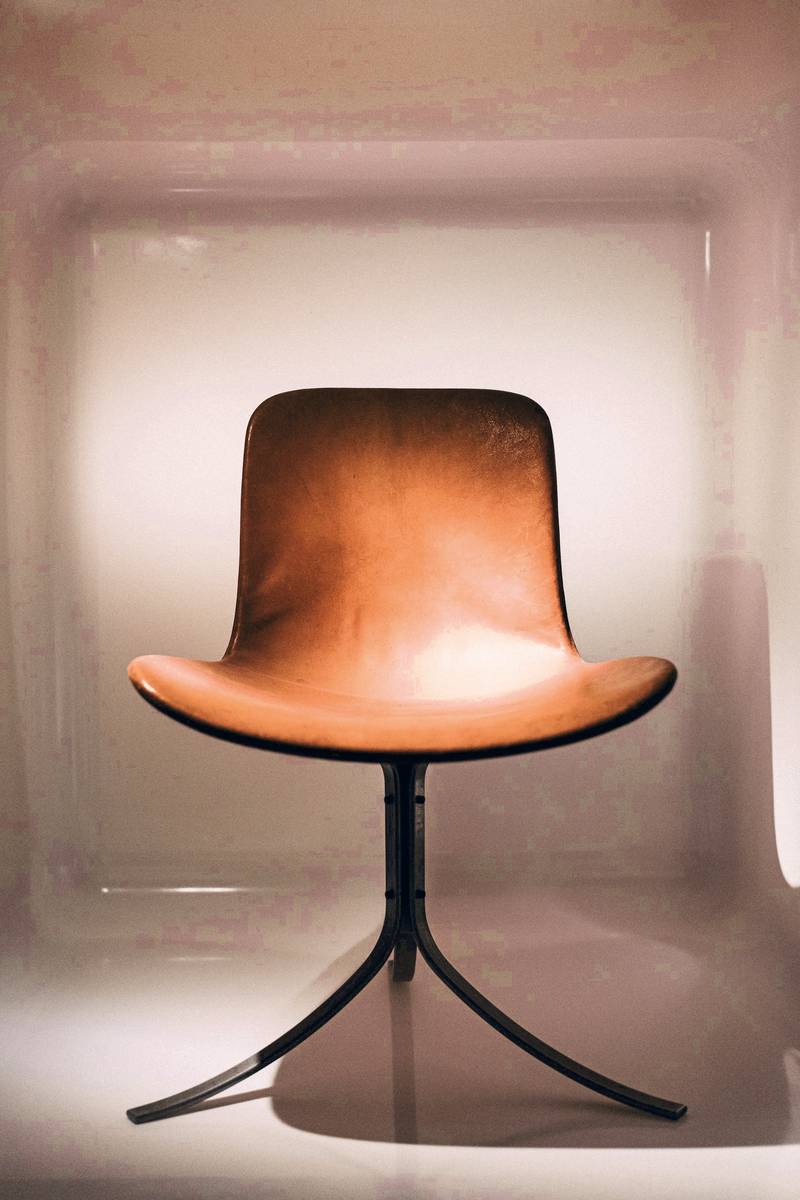 Silla de asiento curvo con reflejos de cobre sobre patas finas
