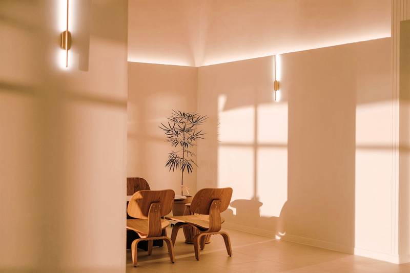 Sala bañada de luz dorada con sillas de madera moldeada